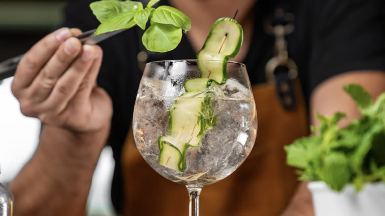 A hand garnishing a Kew Garden cocktail 