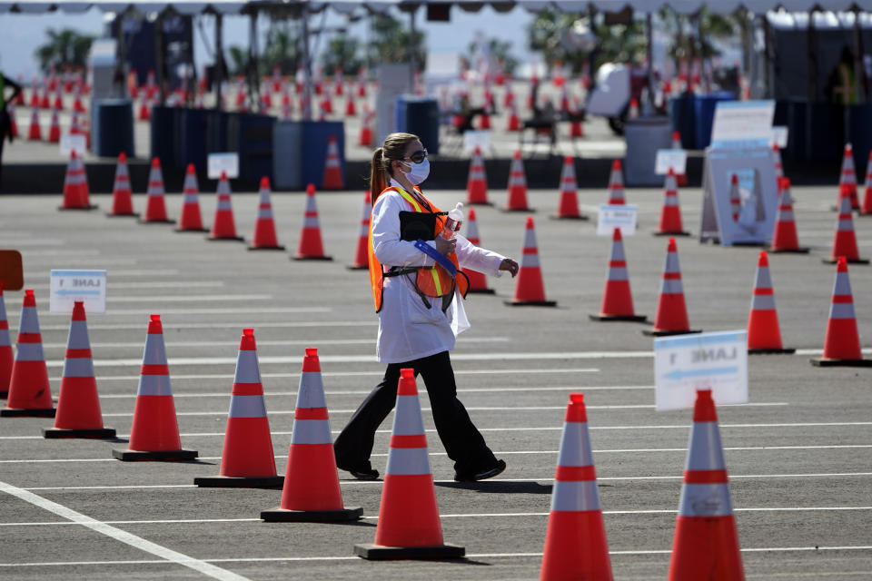 Sossie Bedrossian, head of nursing for the Los Angeles school district, walks in the parking lot of a COVID-19 vaccination site for district employees at SOFI Stadium Tuesday, March 2, 2021, in Inglewood, Calif. (AP Photo/Marcio Jose Sanchez)