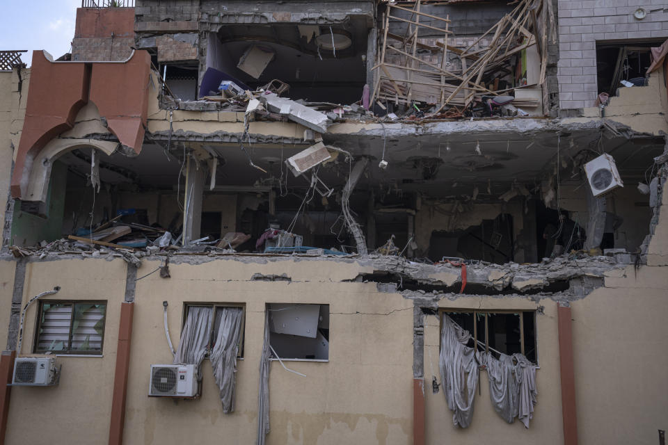 Palestinians inspect damage to their building following Israeli airstrikes on an apartment of an Islamic Jihad commander in Gaza City, Tuesday, May 9, 2023. The Israeli military says it has killed three senior commanders of the militant Islamic Jihad group in targeted airstrikes. Palestinian health officials said 13 people were killed in total in Tuesday's attacks, including the commanders, their wives, several of their children and others nearby. (AP Photo/Fatima Shbair)