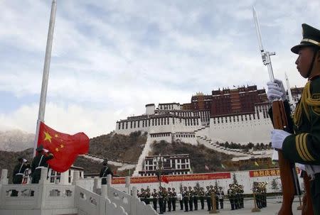 Paramilitary policemen salute the Chinese flag during its raising ceremony to celebrate Tibet's second Serfs Emancipation Day in front of the Potala Palace in Lhasa, Tibet March 28, 2010. REUTERS/China Daily/Files