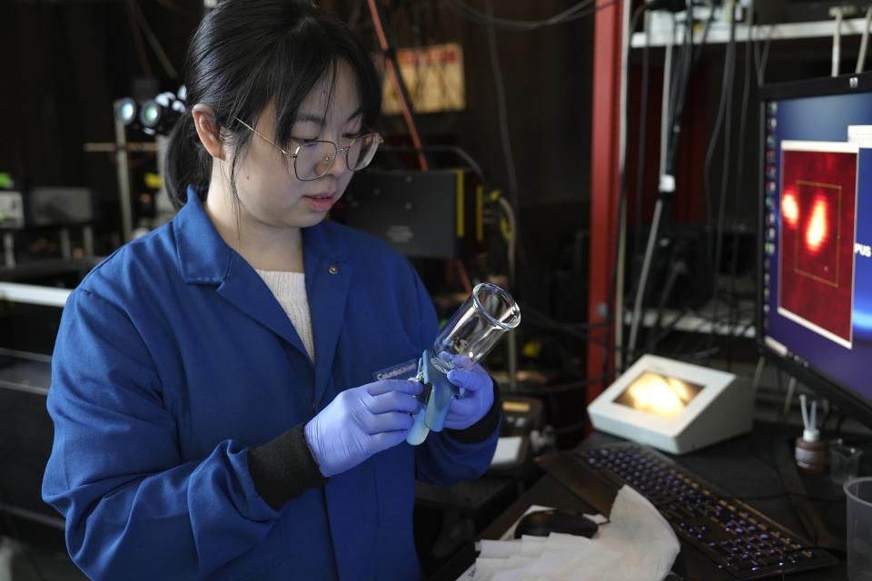 Naixin Qian, a Columbia physical chemist, places a sample containing nanoplastics, microscopic plastic pieces, under a microscope in New York on Monday, Jan. 8, 2024. A new study found the average liter of bottled water has nearly a quarter million invisible pieces of nanoplastics, detected and categorized for the first time by a microscope. (AP Photo/Mary Conlon)