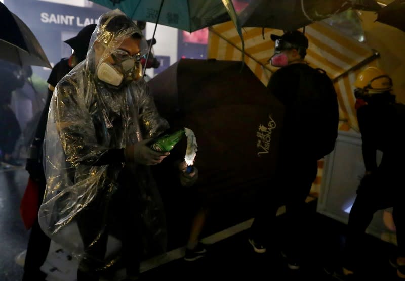 An anti-government demonstrator lights up a molotov cocktail during protests at Tsim Sha Tsui, in Hong Kong