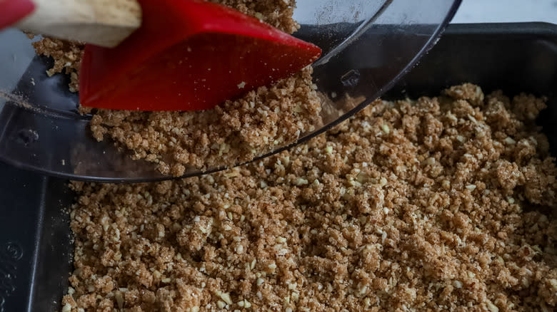 topping being spread over cake