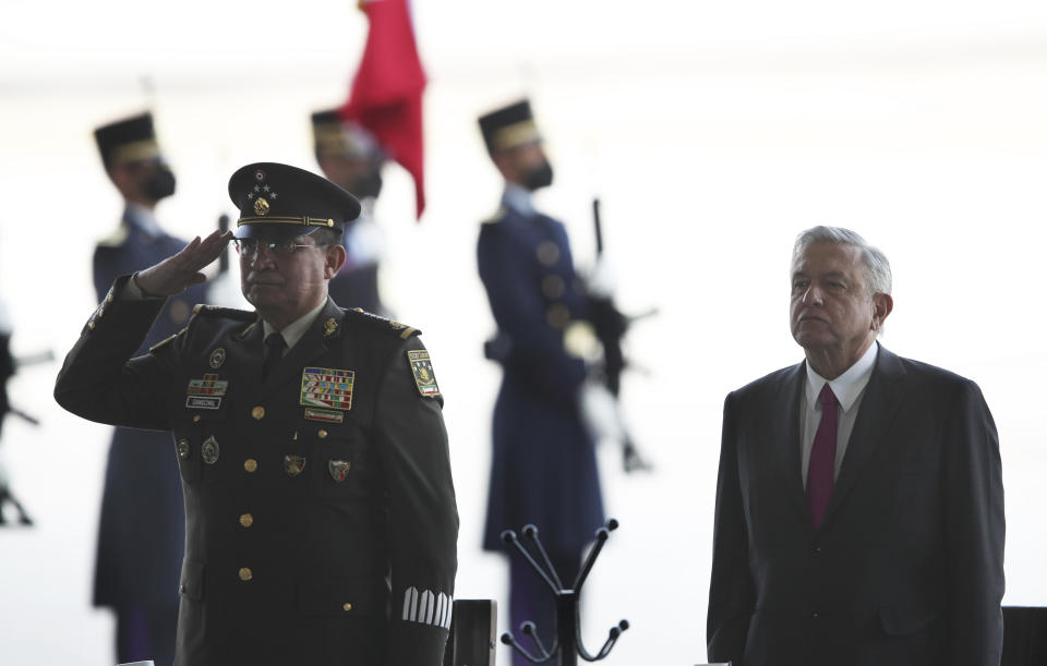 FILE - Mexico's Defense Secretary Luis Crescencio Sandoval salutes standing next to President Andres Manuel Lopez Obrador during a ceremony inaugurating a new runway at the Santa Lucia military air base north of Mexico City, Feb. 10, 2021, converted to supplement the capital's overtaxed international airport. The airport was finished and inaugurated in March, but it remains little-used. (AP Photo/Marco Ugarte, File)