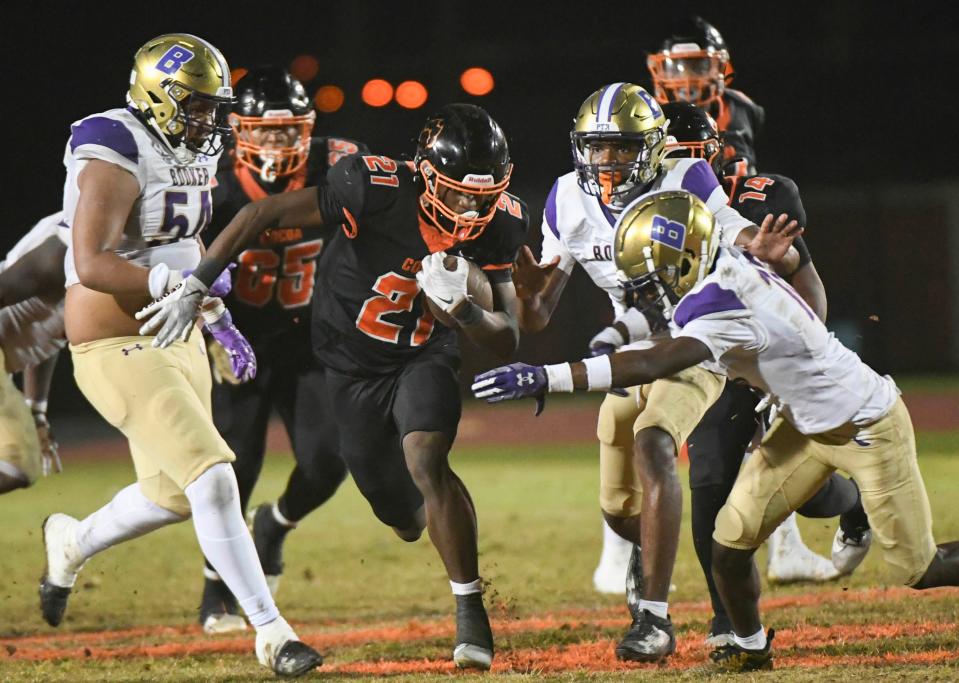 Demarion “Tank” Walker of Cocoa runs between a trio of Booker defenders in the FHSAA football Class 2S state semifinal Friday, December 1, 2023. Craig Bailey/FLORIDA TODAY via USA TODAY NETWORK