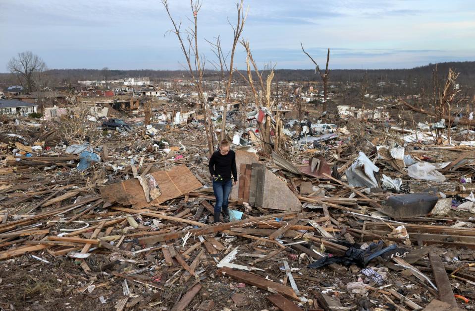 <span class="caption">A woman searches through debris near where her Dawson Springs, Ky. home stood before a tornado flattened it in December 2021.</span> <span class="attribution"><a class="link " href="https://www.gettyimages.com/detail/news-photo/woman-searches-for-her-possessions-in-a-debris-field-near-news-photo/1359043662" rel="nofollow noopener" target="_blank" data-ylk="slk:Scott Olson/Getty Images;elm:context_link;itc:0;sec:content-canvas">Scott Olson/Getty Images</a></span>