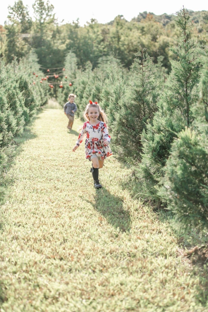 Children running amid the trees and Pinewood Christmas Trees in Williamson County.