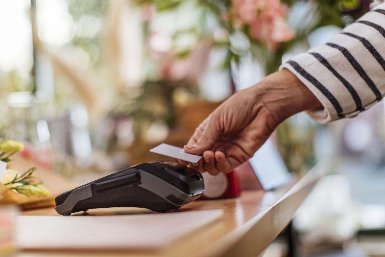 Unrecognizable person making a contactless credit card payment at the flower shop