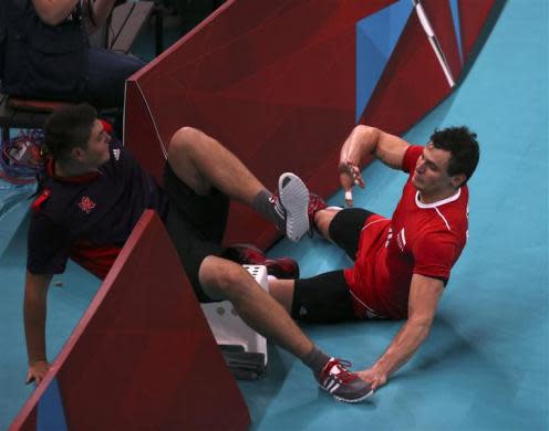 Poland's Zbigniew Bartman (R) crashes into a ball boy as he chases the ball during their men's Group A volleyball match against Bulgaria at the London 2012 Olympic Games at Earls Court July 31, 2012.