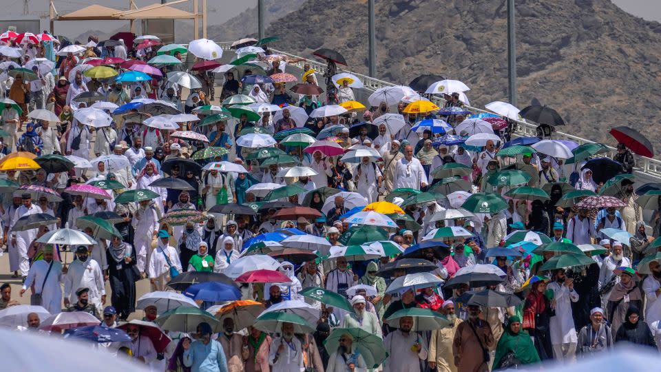 Muslim pilgrims use umbrellas to shield themselves from the sun as they arrive to cast stones at pillars in the symbolic stoning of the devil, in Mina, near Mecca, Saudi Arabia, on June 18. - Rafiq Maqbool/AP