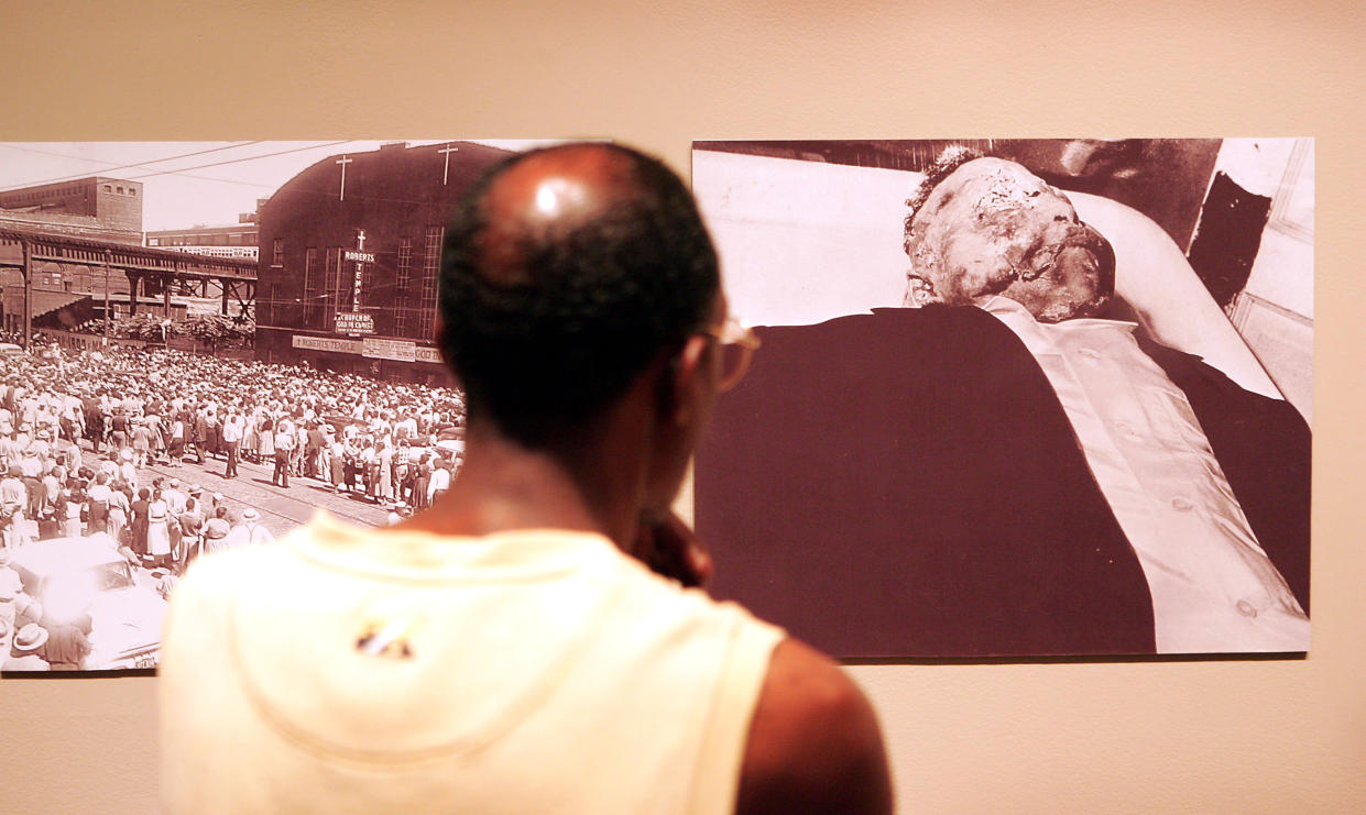 Leon Smith examines photographs from the funeral of Emmett Till 