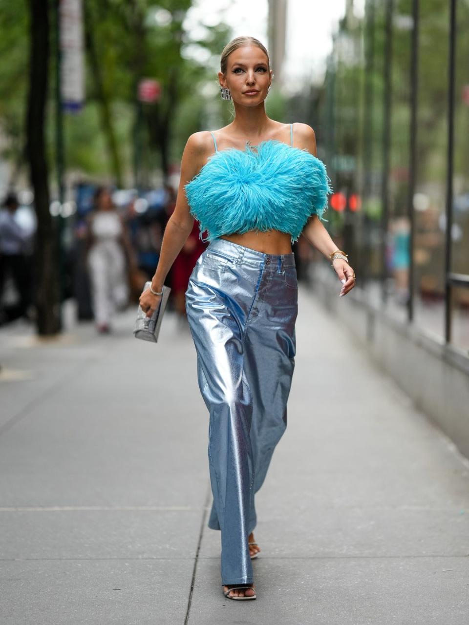 Leonie Hanne wears wears a blue fluffy crop top and metallic trousers 