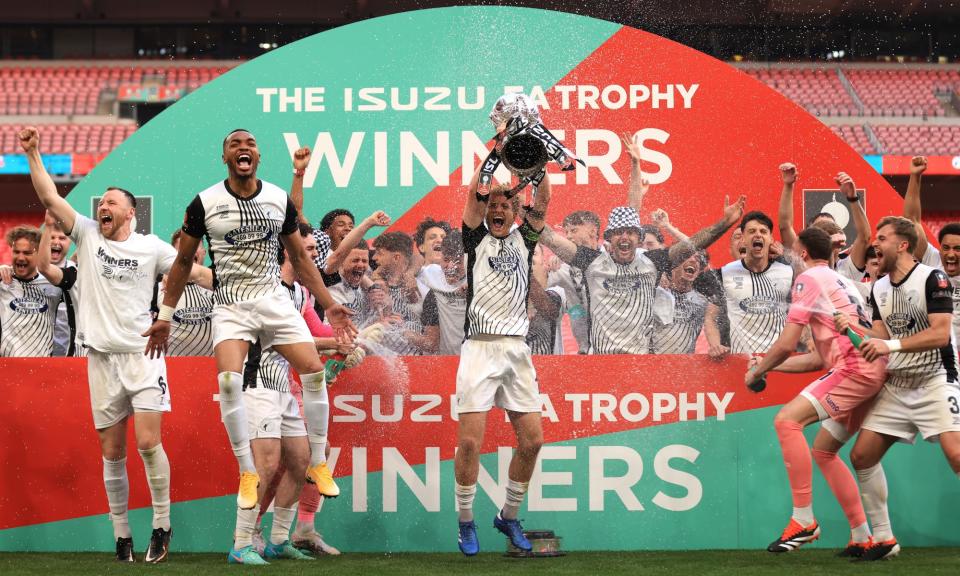 <span>Greg Olley lifts the FA Trophy as Gateshead celebrate their Wembley success.</span><span>Photograph: Stephen Pond/The FA/Getty Images</span>