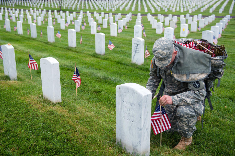 A U.S. Army 3d U.S. Infantry Regiment (The Old Guard) Soldier places American flags at headstones in Section 64 of Arlington National Cemetery during Flags In, May 21, 2015, in Arlington, Virginia. The Old Guard has held this honor and privilege of conducting Flags In since 1948.