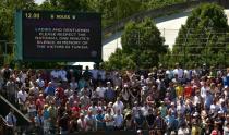 Spectators and staff stand for a minute's silence in memory of the victims of the June 26 Tunisia attacks on day five of the 2015 Wimbledon Championships at The All England Tennis Club in Wimbledon, London, July 3, 2015