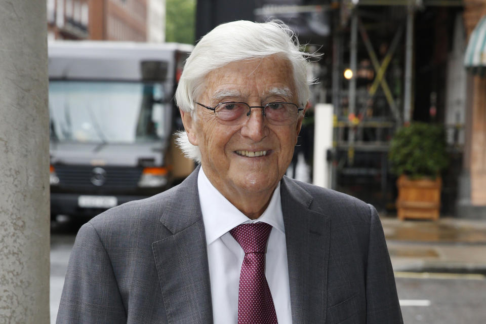 FILE - British broadcaster, journalist and author Michael Parkinson poses for photographers as he arrives for the memorial of broadcaster Alan Whicker, in central London, Wednesday, May 28, 2014. Michael Parkinson, the renowned British broadcaster who interviewed everyone from Muhammed Ali, David Bowie and Miss Piggy, has died. He was 88. In a statement Thursday, Aug. 17, 2023 to the BBC, his family said Parkinson died “peacefully at home last night in the company of his family.