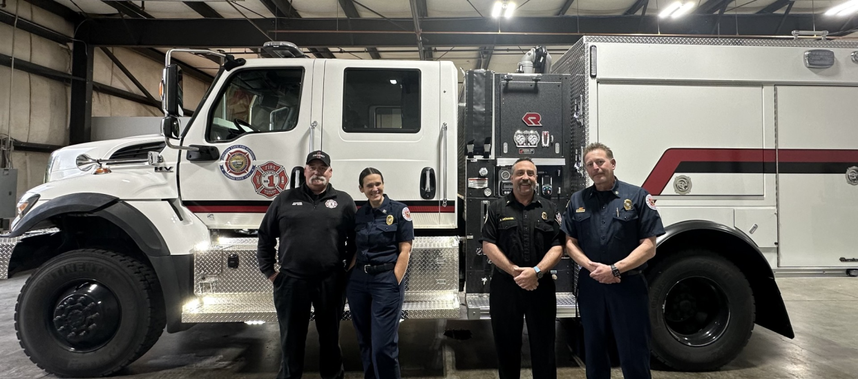 Marion County Fire district operations officer Troy Jurgens, division chief Mariah Rawlins, fire chief Kyle McMann and chief deputy state fire marshal Travis Medema stand in front of the new fire engine given to the department by the state.