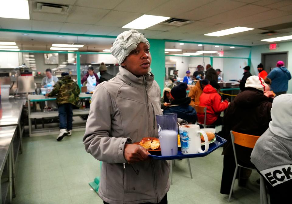 Fatima Phelps, 31, takes her hot breakfast to a table at Our Daily Bread in Over-the-Rhine, on Jan. 31. She is among a growing number of people without homes who are sleeping outside. The soup kitchen, the largest in the region, served 170,000 hot meals in 2023, up from about 118,000 in 2019, before the COVID-19 pandemic hit.