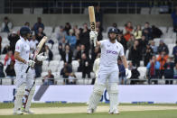 England's Jonny Bairstow, right, raises his bat to celebrate scoring fifty runs during the fifth day of the third cricket test match between England and New Zealand at Headingley in Leeds, England, Monday, June 27, 2022. (AP Photo/Rui Vieira)