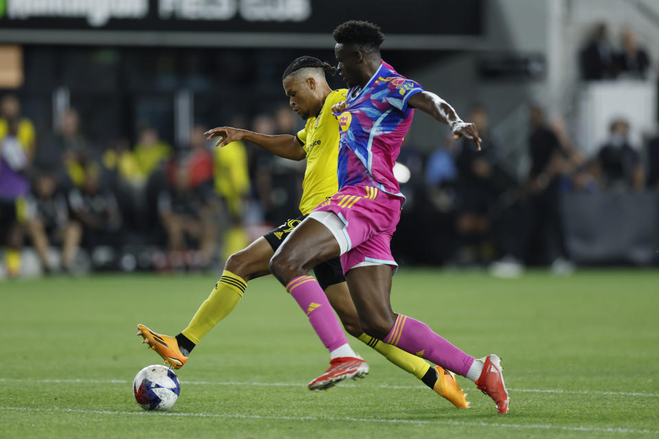Columbus Crew's Jacen Russell-Rowe, left, dribbles past Toronto FC's Aime Mabika during the second half of an MLS soccer match Saturday, Aug. 26, 2023, in Columbus, Ohio. (AP Photo/Jay LaPrete)