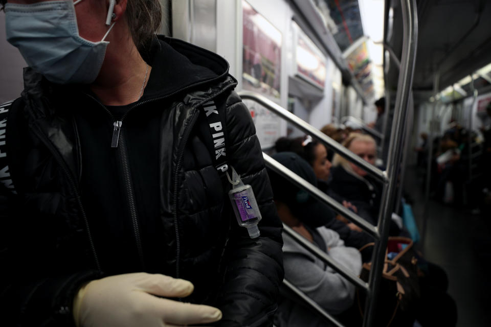 NEW YORK, USA - MARCH 11: A woman wears a face mask, surgical gloves and a hand sanitizer attached herself to prevent Covid-19 spread, at the New York City subway train in New York, United States on March 11, 2020. (Photo by Tayfun Coskun/Anadolu Agency via Getty Images)