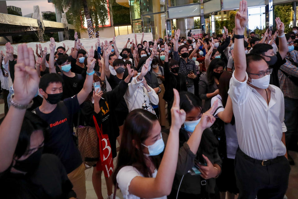 Pro-democracy activists flash three-fingered salutes during a rally outside Siam Paragon, one of the largest shopping malls, in Bangkok, Thailand, Tuesday, Oct. 20, 2020. Thailand's Cabinet on Tuesday approved a request to recall Parliament for a special session to deal with the political pressures from ongoing anti-government protests. The Cabinet at its weekly meeting approved the request, which calls for a non-voting session on Oct. 26-27. (AP Photo/Sakchai Lalit)