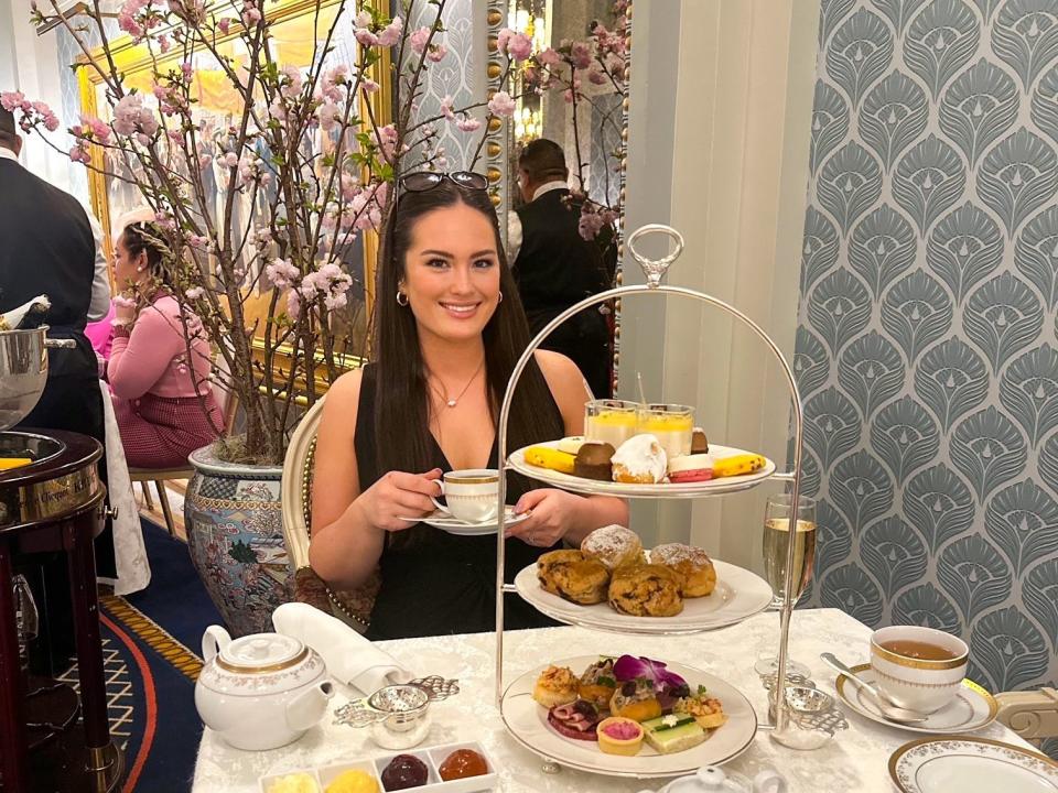 Author Hayley Hutson holding teacup at a cherry-blossom tea