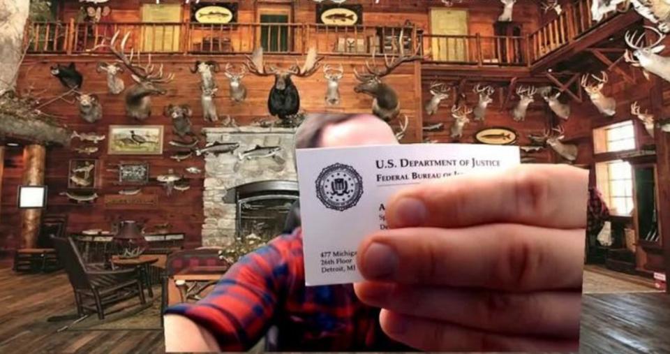 McCaffrey holds up an FBI agent's business card to the camera during a 2017 livestream. The nature of his relationship with the agency is unclear. (Photo: Screenshot)