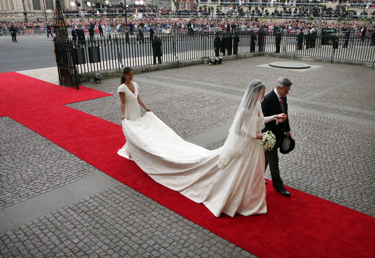 Kate Middleton is escorted by her father Michael (R) and sister Pippa (L) at Westminster Abbey for her wedding to Prince William in London April 29, 2011. REUTERS/Tom Pilston/POOL  (BRITAIN - Tags: SPORT SOCCER ROYALS ENTERTAINMENT PROFILE)