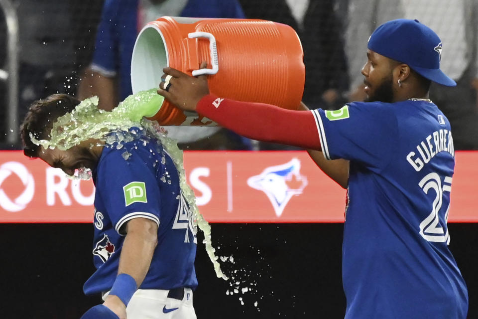 Toronto Blue Jays' Spencer Horwitz, left, is doused by teammate Vladimir Guerrero Jr. following their team's victory over the Houston Astros in a baseball game, Tuesday, July 2, 2024, in Toronto. (Jon Blacker/The Canadian Press via AP)