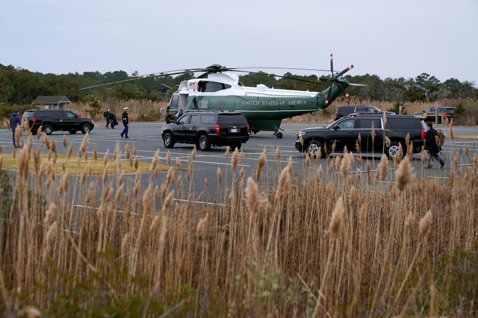Motorcade vehicles roll into position outside Marine One, with President Joe Biden and first lady Jill Biden aboard, at a landing zone at Gordons Pond near Rehoboth Beach, Del., Monday, Dec. 27, 2021.