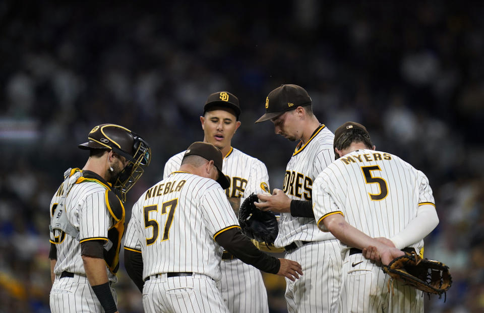 San Diego Padres starting pitcher Blake Snell, second from right, talks with pitching coach Ruben Niebla (57) on the mound during the fifth inning of a baseball game against the Los Angeles Dodgers, Saturday, Sept. 10, 2022, in San Diego. (AP Photo/Gregory Bull)