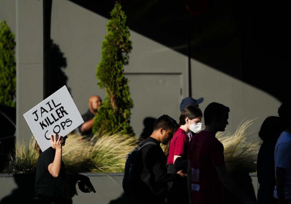 A protester holds a sign reading, "Jail killer cops," as people march through downtown Seattle after body camera footage was released of a Seattle police officer joking about the death of Jaahnavi Kandula, a 23-year-old woman hit and killed in January by officer Kevin Dave in a police cruiser, Thursday, Sept. 14, 2023, in Seattle. (AP Photo/Lindsey Wasson)