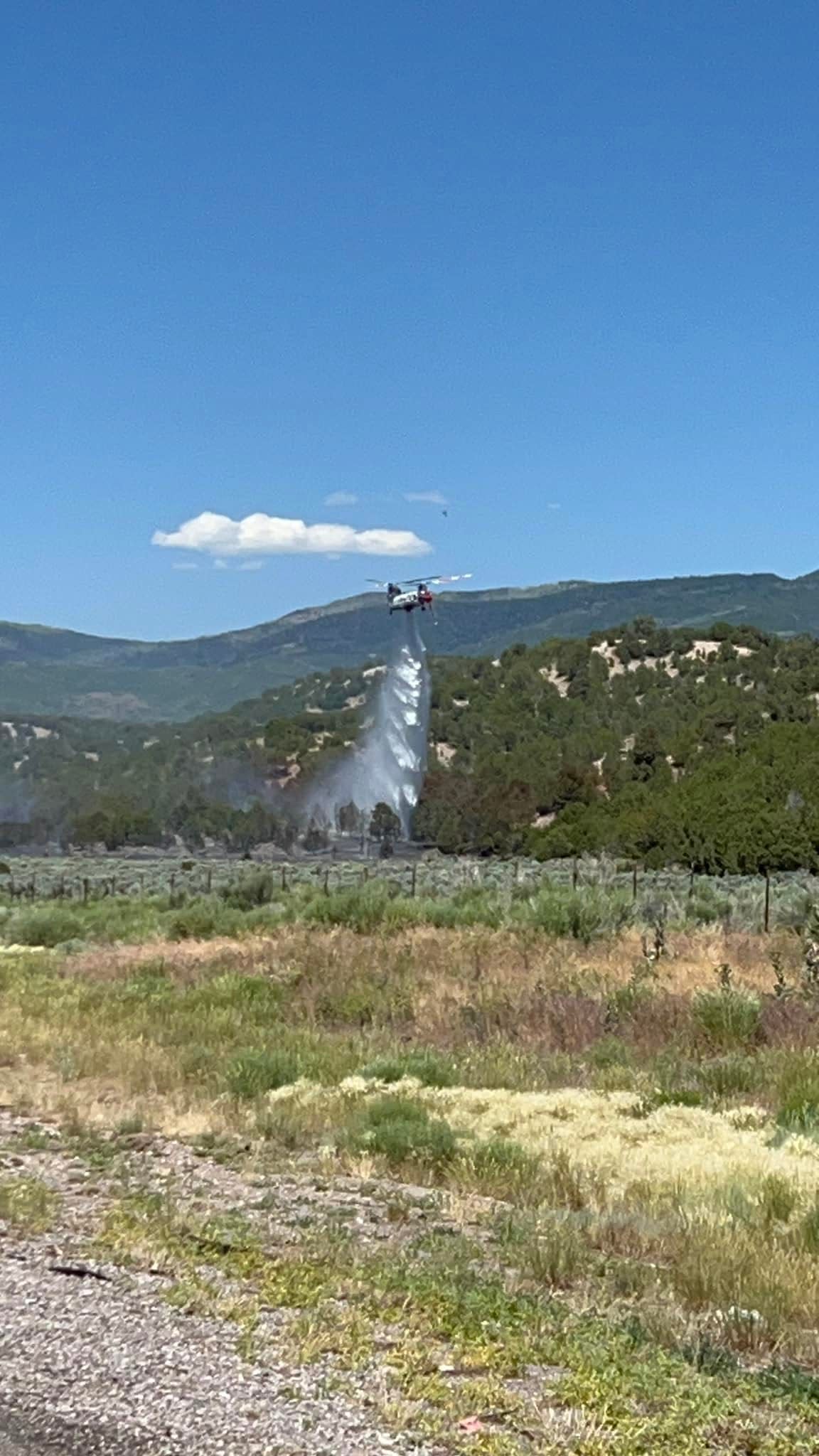 A helicopter fights a wildfire that started just north of Beaver on Interstate 15 on Friday. The blaze grew to about 40 acres and forced a temporary closure of the freeway.