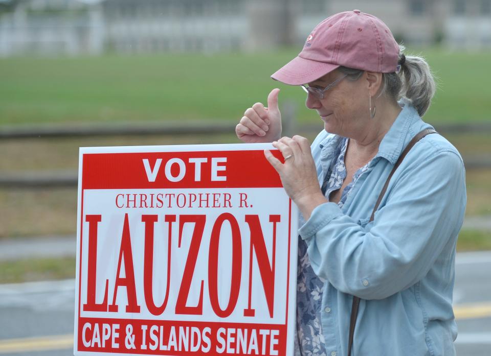 Linda Lauzon, mother of candidate Christopher Lauzon, gives the thumbs up to a driver leaving the polls at the Harwich Community Center. To see more photos, go to www.capecodtimes.com/news/photo-galleries.