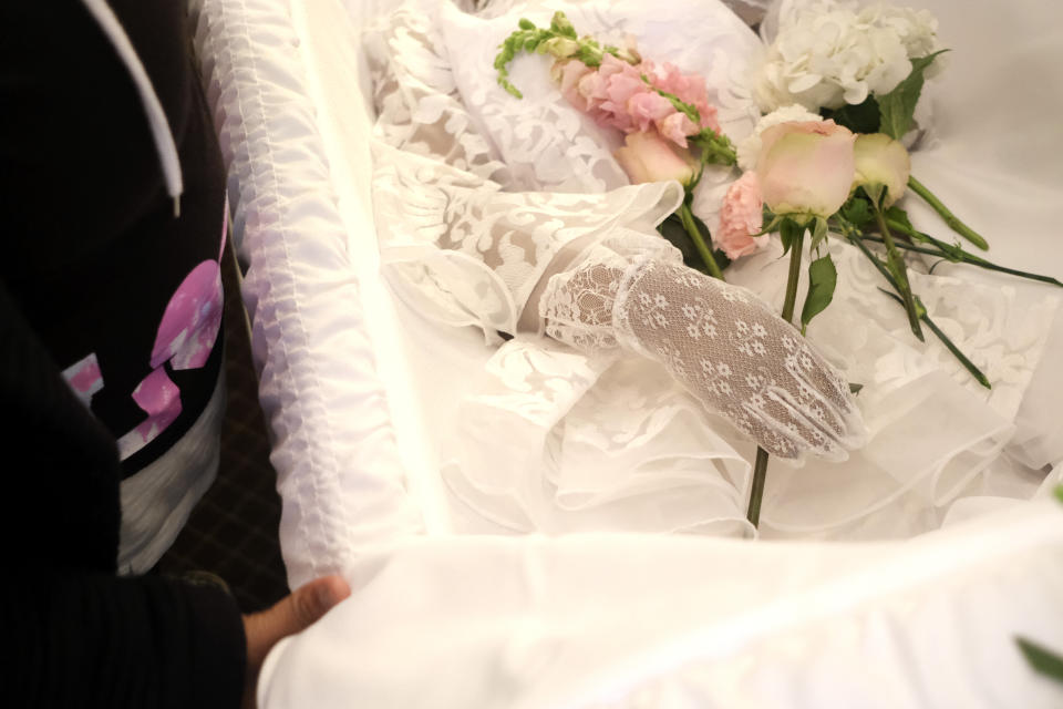 Nahasia Robinson, who died at age 27, is seen with flowers in her hands during a viewing at The Family Funeral Home, Thursday April 30, 2020, in Newark, N.J. A wave of shaken families has had to honor the dead apart and in small groups during an era of social distancing. (AP Photo/Seth Wenig)