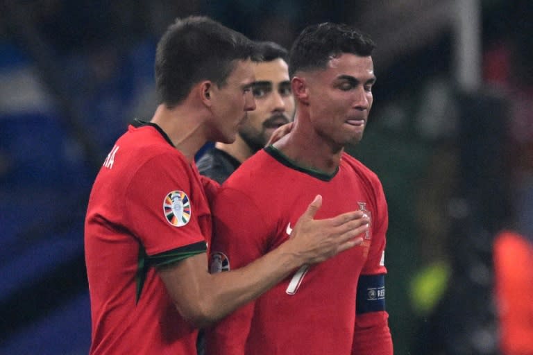 Portugal's Cristiano Ronaldo (R) reacts to his missed penalty kick against Slovenia (Kirill KUDRYAVTSEV)