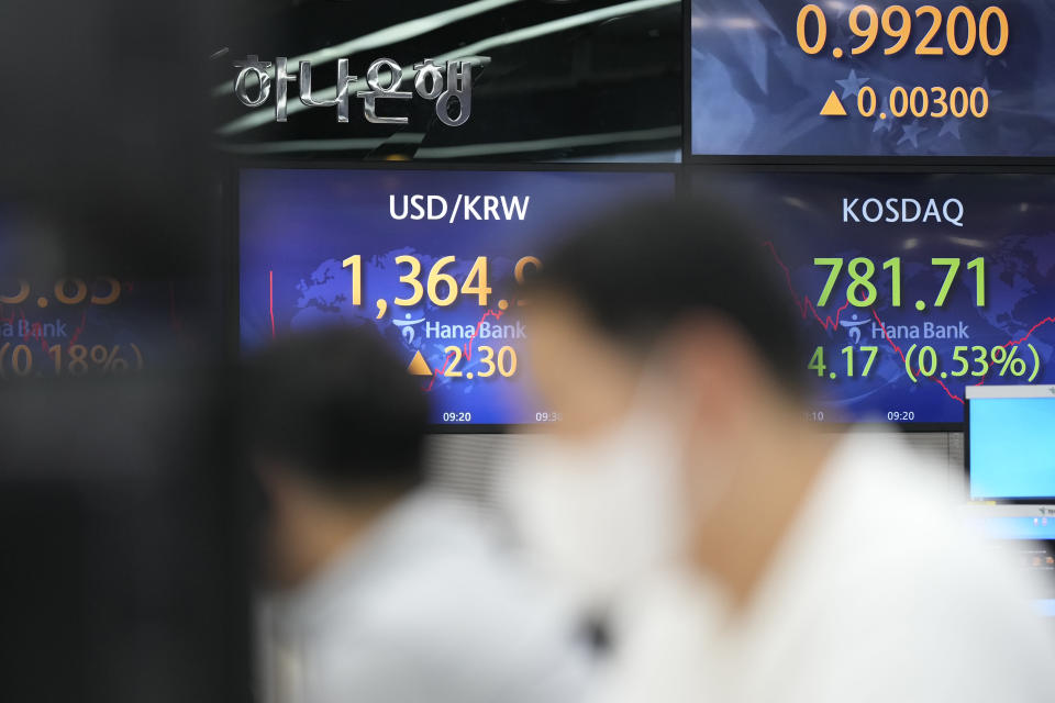 A currency trader walks by the screens showing the foreign exchange rate between U.S. dollar and South Korean won, center, and the Korean Securities Dealers Automated Quotations (KOSDAQ), right, at a foreign exchange dealing room in Seoul, South Korea, Monday, Sept. 5, 2022. Asian stock markets declined Monday after Wall Street ended last week lower and China tightened anti-virus controls. (AP Photo/Lee Jin-man)