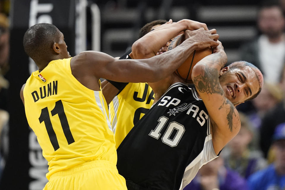 San Antonio Spurs forward Jeremy Sochan (10) battles Utah Jazz guard Kris Dunn (11) for a.loose ball during the second half of an NBA basketball game Tuesday, Feb. 28, 2023, in Salt Lake City. (AP Photo/Rick Bowmer)