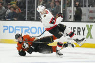 Anaheim Ducks' Josh Manson, bottom, falls to the ice after he collided with Ottawa Senators' Josh Norris during the first period of an NHL hockey game Friday, Nov. 26, 2021, in Anaheim, Calif. (AP Photo/Jae C. Hong)