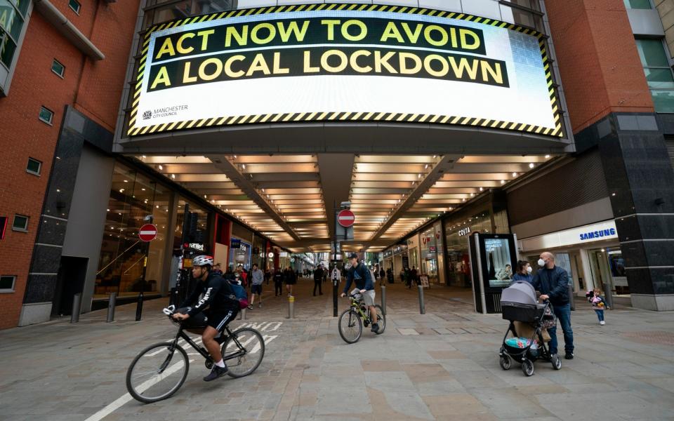 A public information message in central Manchester after Boris Johnson's set out new restrictions to last 'perhaps six months' - AP