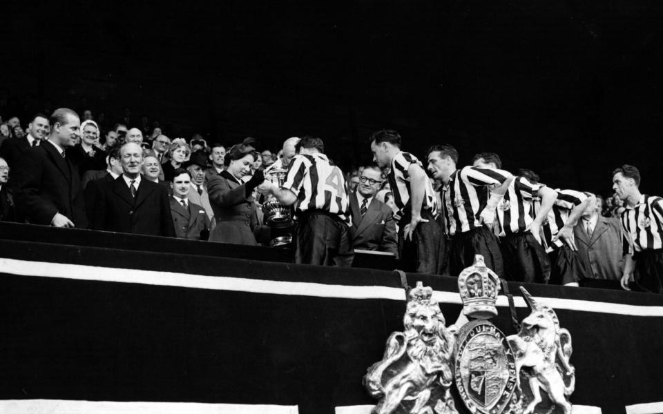 HM The Queen presents the FA Cup to the Captain of the winning Newcastle United side after their 3-1 victory over Manchester City at Wembley.  - Fox Photos/Getty Images