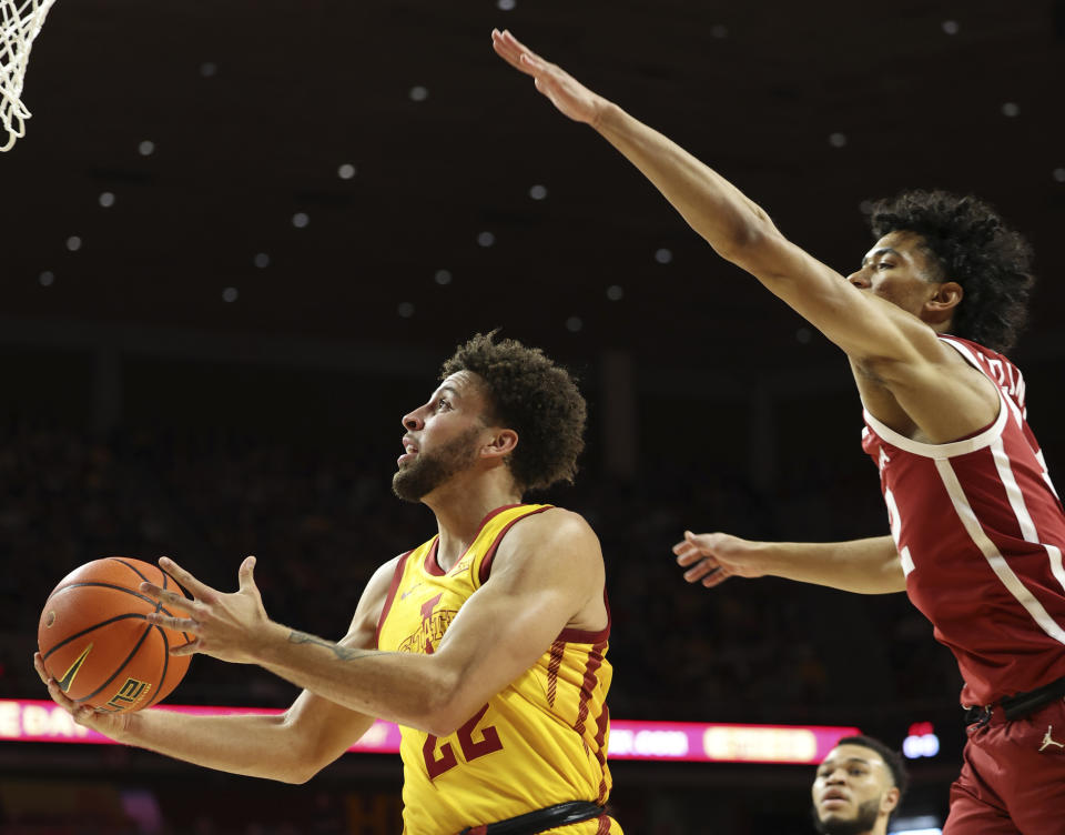 Iowa State guard Gabe Kalscheur (22) goes in for a lay-up around Oklahoma guard Milos Uzan (12) during the first half of an NCAA college basketball game, Saturday, Feb. 25, 2023, in Ames, Iowa. (AP Photo/Justin Hayworth)