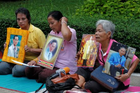 Well-wishers hold portraits of Thailand's King Bhumibol Adulyadej at Siriraj Hospital in Bangkok, Thailand, October 11, 2016. REUTERS/Chaiwat Subprasom