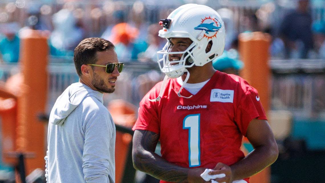 Miami Dolphins head coach Mike McDaniel talks with Dolphins quarterback Tua Tagovailoa (1) during NFL football training camp at Baptist Health Training Complex in Hard Rock Stadium on Sunday, July 30, 2023 in Miami Gardens, Florida.