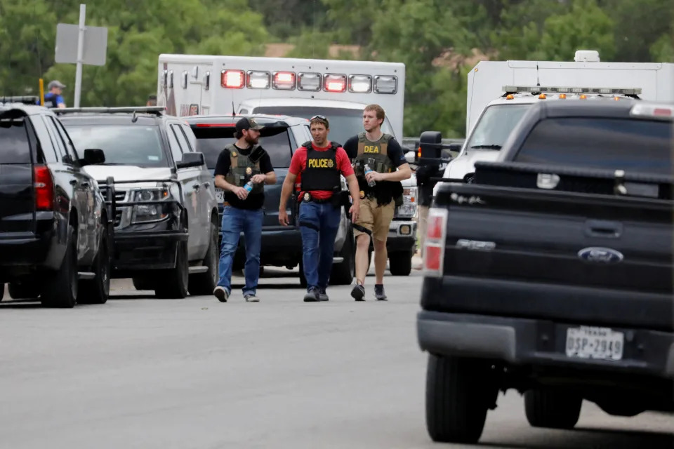 Law enforcement officers walk near the scene of a shooting at Robb Elementary School in Uvalde, Texas, U.S. May 24, 2022. REUTERS/Marco Bello