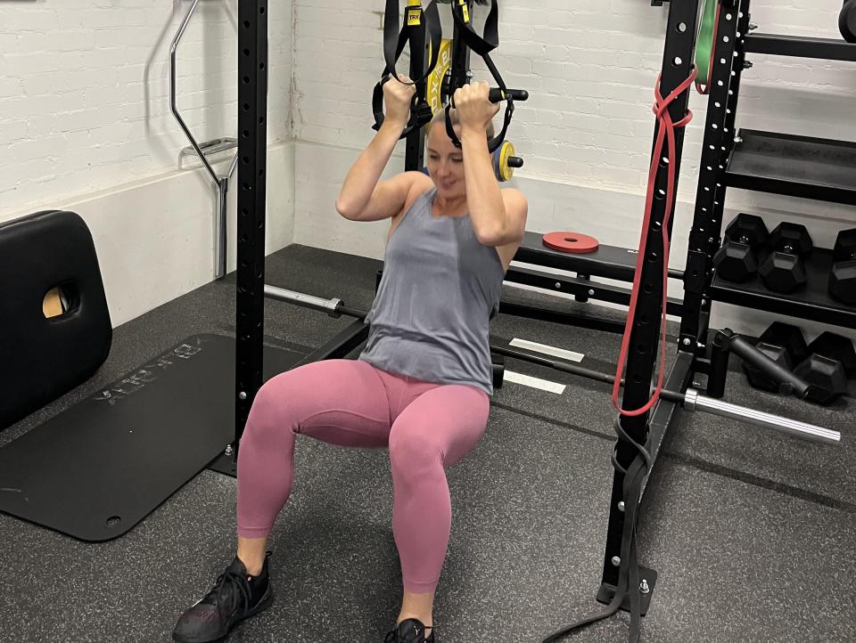 Rachel performing assisted pull-ups using the TRX.