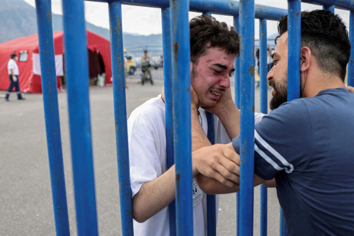 Syrian survivor Mohammed, 18, who was rescued with other refugees and migrants off Greece after their boat capsized, cries as he is reunited with his brother Fadi, who came to meet him from the Netherlands, in the port of Kalamata, Greece, on June 16, 2023. / Credit : STELIOS MISINAS / REUTERS