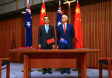 FILE PHOTO: Australia's Prime Minister Malcolm Turnbull stands with Chinese Premier Li Keqiang before the start of an official signing ceremony at Parliament House in Canberra, Australia, March 24, 2017. REUTERS/David Gray/File photo