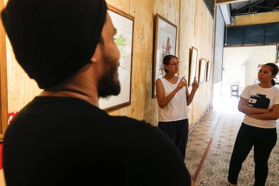 Esther Geh explaining her artwork called ‘Of Limited Palette’ at the Tu7oh Exhibition in George Town July 6, 2022. ― Picture by Sayuti Zainudin